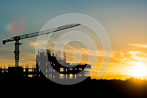 Construction site and crane over sunset background