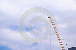 Construction site with crane on sky background. Big yellow machinery construction crane tool of building industry for heavy