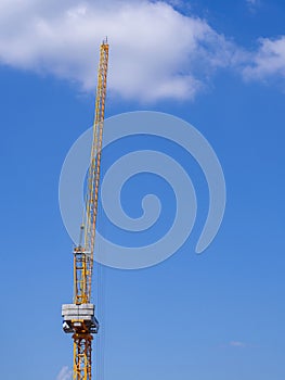 Construction site with a crane on sky background. Big yellow machinery construction crane tool of building industry for heavy