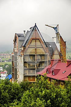 Construction site with crane and unfinished cottage in Ukrainian Carpathian village