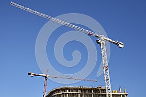 Construction site cranes against the blue sky