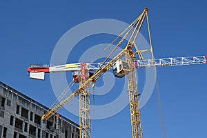 Construction site cranes on background of blue sky