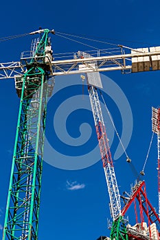 Construction site with cranes, blue sky on the background