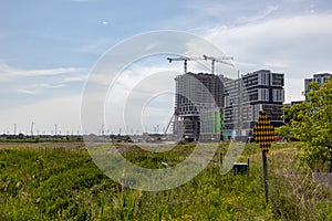 Construction site - cranes - buildings - greenery - blue sky