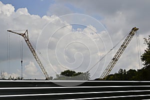 Construction site with cranes and cloudy sky on the background