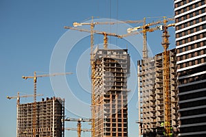 Construction site. Cranes and concrete buildings. Investing in new real estate