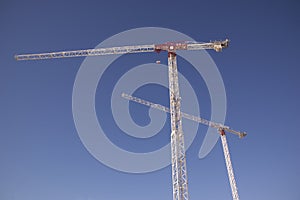 Construction site with cranes and fences with warning signs