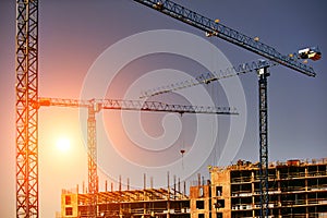 Construction site with cranes on sky background. Sunny day