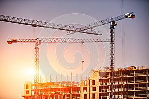 Construction site with cranes on sky background. Sunny day