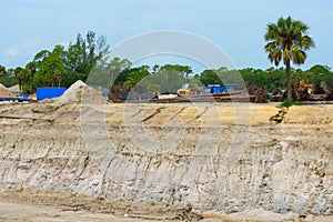 Construction site with deep hole excavation and work trucks