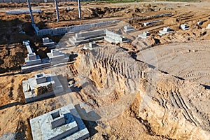 A construction site in the desert, showing heavy machinery, workers, and materials being used for building