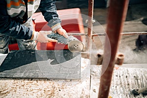 Construction site details - industrial tool, hand grinder of worker cutting marble