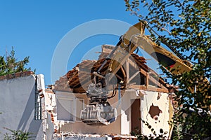 Construction site digger yellow demolishing house for reconstruction photo