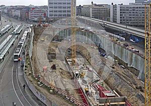 Construction site with excavation, heavy machinery, cranes, tram