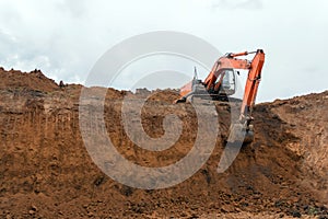 The construction site excavator digs a deep pit. Construction machinery. Excavation at a construction site