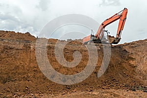 The construction site excavator digs a deep pit.