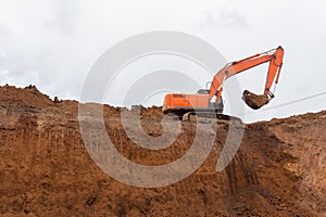 The construction site excavator digs a deep pit. Excavation at a construction site