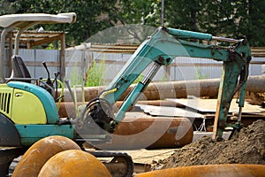 Construction site, excavator wearing metal pipe dust