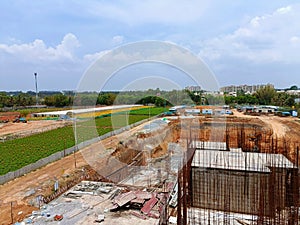Construction site with farmlands and skyscrapers in the vicinity on the outskirts of Bangalore