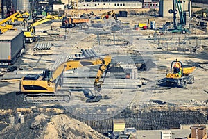 Construction site with heavy machines in the urban populated area