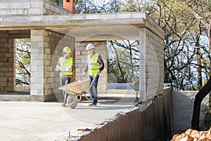 Building engineer and mason during a construction site visit, construction of a house