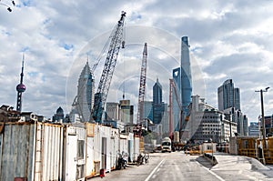 Construction site with houses and a construction crane on the background of skyscrapers of Shanghai