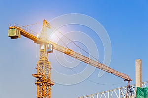 A construction site including several cranes working on a building, Boom crane on the construction of a high-rise and scaffolding