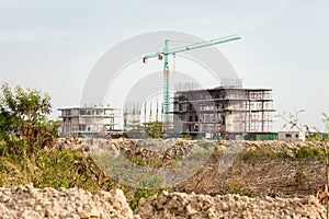 construction site including several cranes working on a building complex.