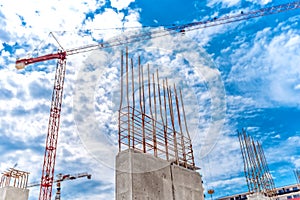 Construction site with industrial crane and close up of reinforced concrete walls, building of skyscraper building