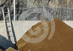 Construction site ladder and heap of gravel