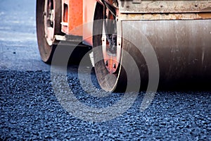 Construction site is laying new asphalt road pavement,road construction workers and road construction machinery scene