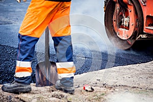 Construction site is laying new asphalt road pavement,road construction workers and road construction machinery scene