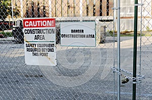 Construction Site With Locked Gate And Caution Sign