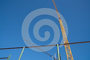 Construction site from low angle with heavy steel formwork and yellow crane