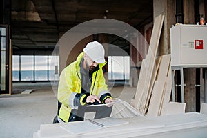 Construction site manager using digital tablet to inspect building progress.