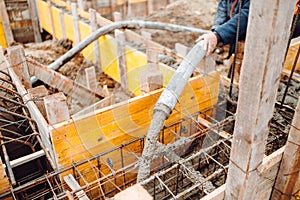 Construction site -  men working on construction site. concrete pouring in castings on Reinforcing steel Bars at construction site