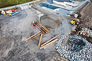 Construction site with metal frames on the ground and heavy machinery. Aerial view. New residential or commercial property