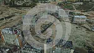 Construction site of a modern city block. High-rise buildings under construction. Construction tower cranes. Aerial photography at