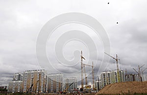 A construction site in Moscow, a lot of cranes and a concrete cut from the blue sky