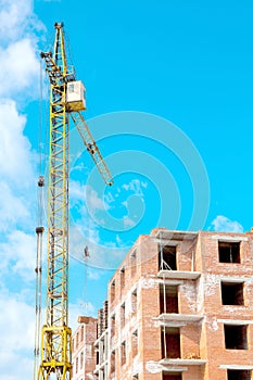 Construction site of a new apartment high building with tower cranes against blue sky. Residential area development. Real estate