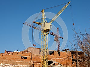 Construction site of a new apartment high building with tower cranes against blue sky. Residential area development. Real estate p