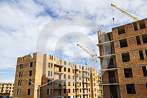 Construction site of a new apartment high building with tower cranes against blue sky. Residential area development. Real estate p