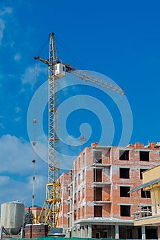 Construction site of a new apartment high building with tower cranes against blue sky. Residential area development. Real estate p