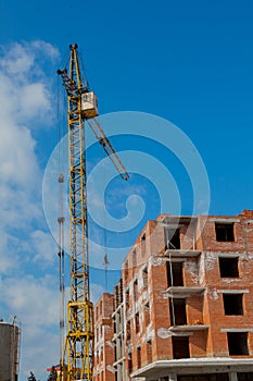 Construction site of a new apartment high building with tower cranes against blue sky. Residential area development. Real estate p