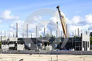 Construction site of a new industrial building, concrete block walls, columns and a telescopic crane