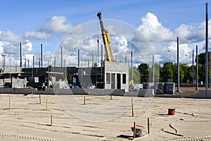 Construction site of a new industrial building, concrete block walls, columns and a telescopic crane