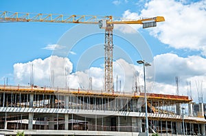 Construction site of new mall or shopping center in the city with cranes machinery, scaffolding, concrete with steel reinforcement