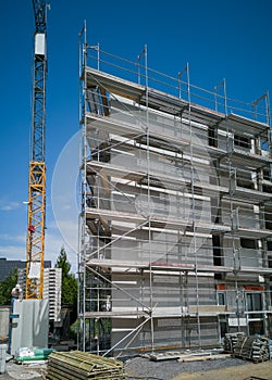 Construction site for a new  multistoried building with scaffold and crane