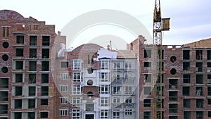 Construction site of new residential building and tower cranes.