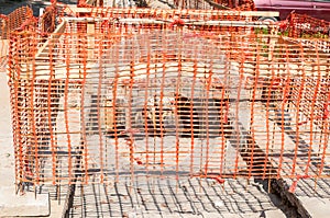 Construction site orange safety net fence as barrier over the trench on the street excavation